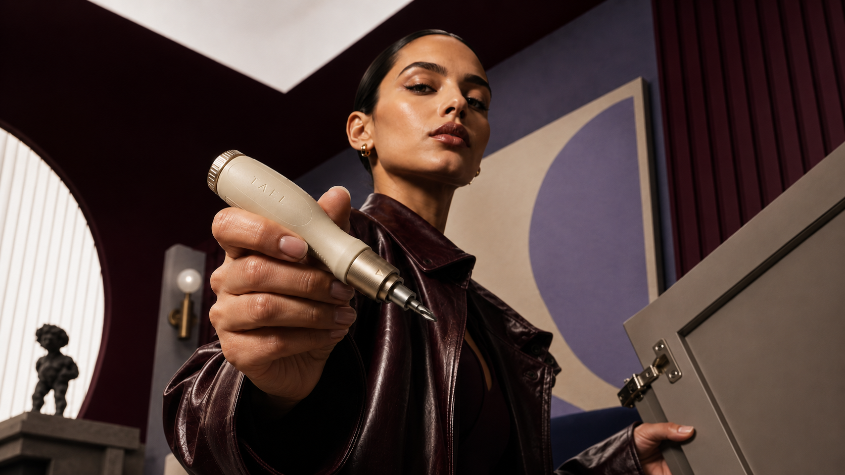 A woman holding the TAEL ratcheting screwdriver toward the camera.